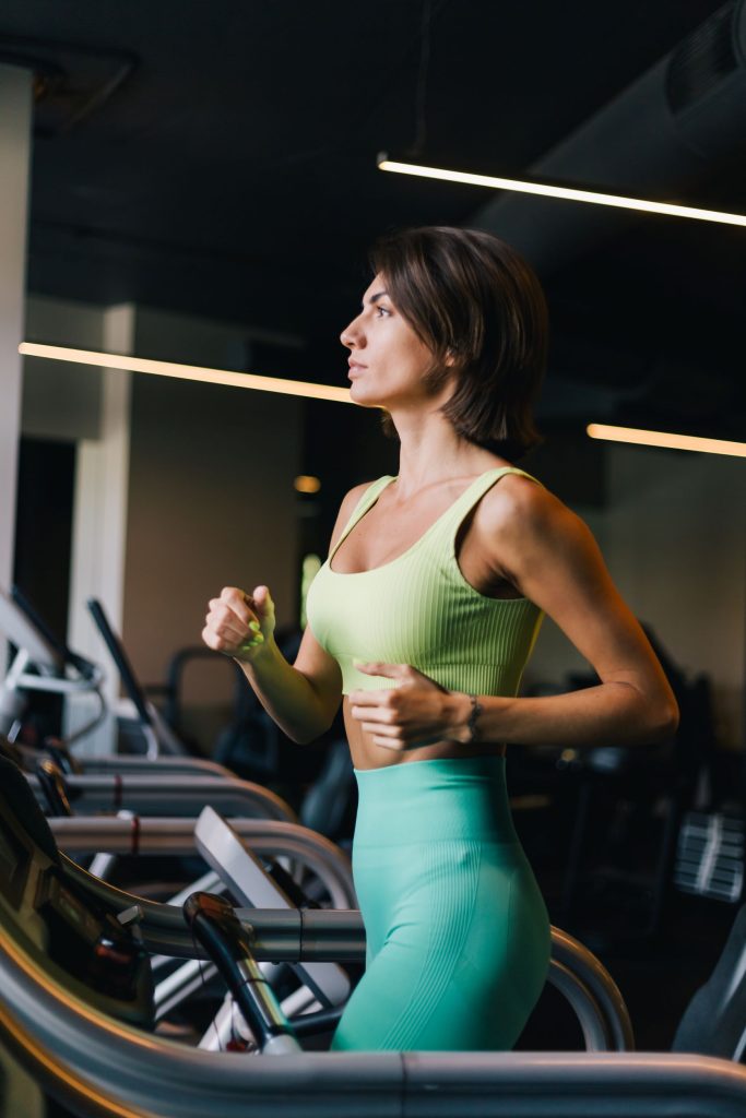 a slim woman running on treadmill